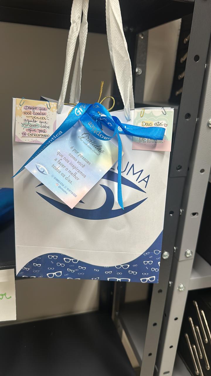 Sacola presente da Óptica Luma com laço e cartão